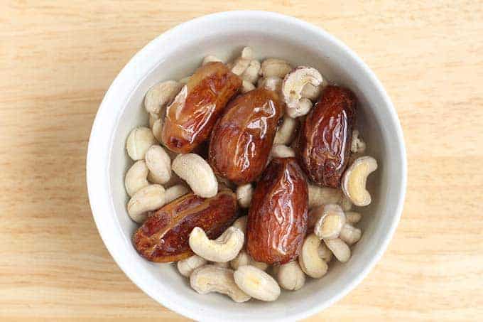 dates and cashews soaking in white bowl
