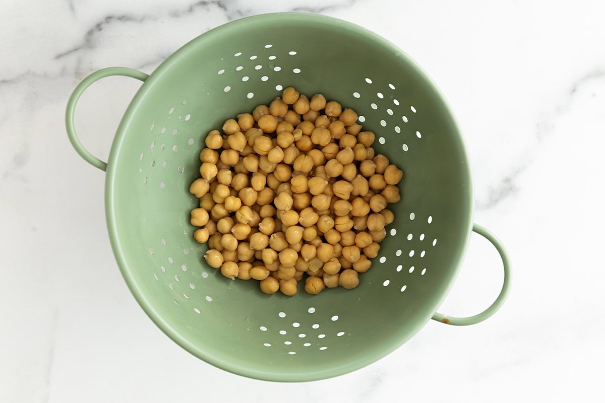 Chickpeas in strainer for beet hummus.