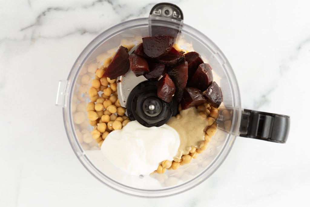 Ingredients for beet hummus in food processor before blending.