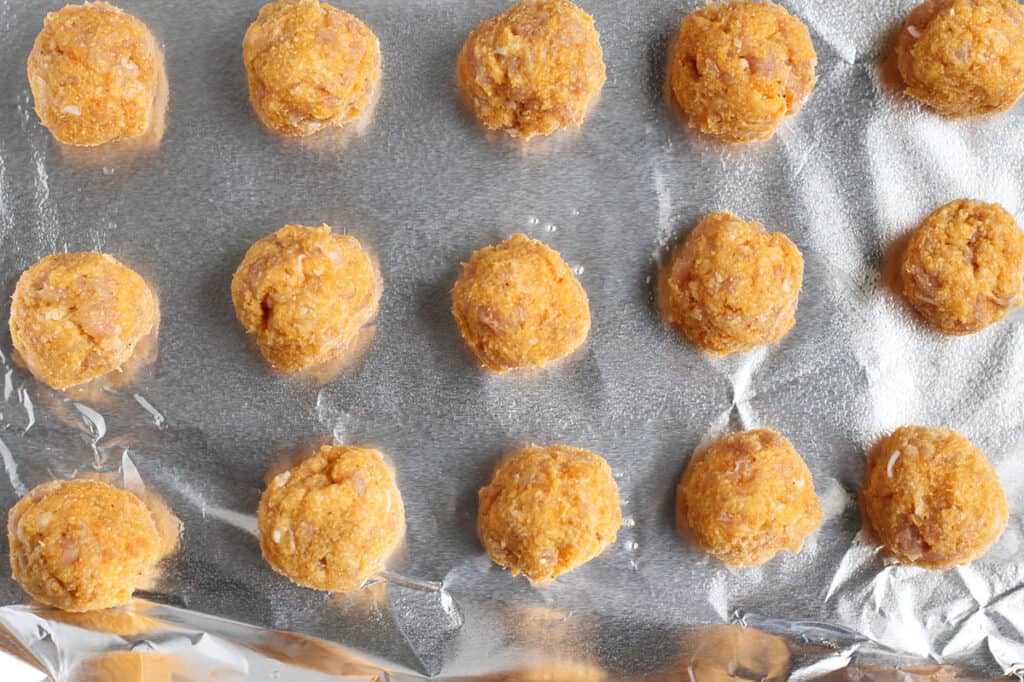 chicken meatballs portioned out on a baking pan.