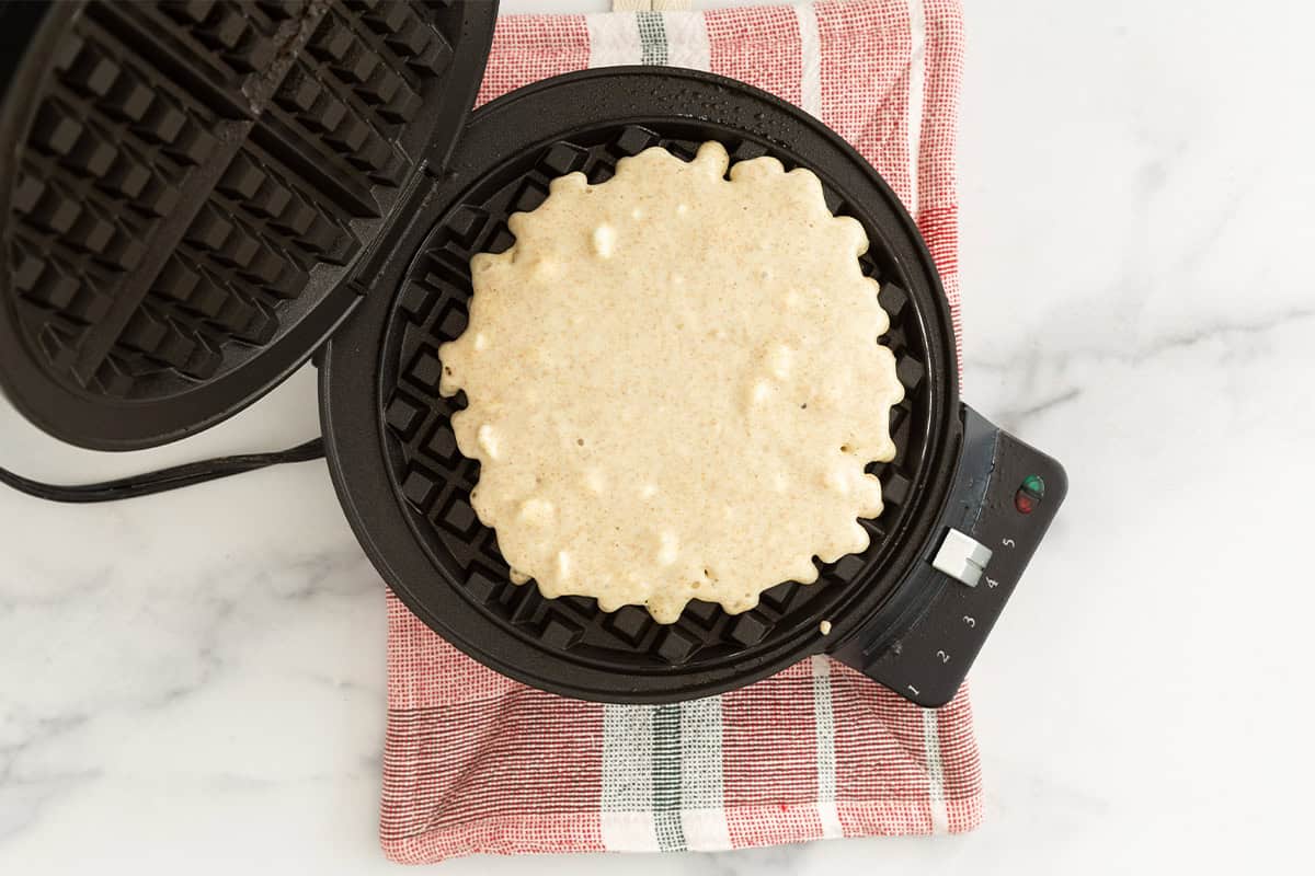 Whole wheat waffle batter in waffle iron before cooking.