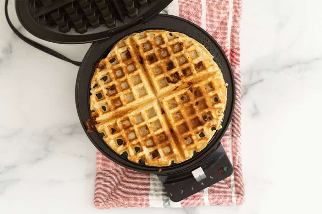 Whole wheat waffle in waffle iron after cooking.