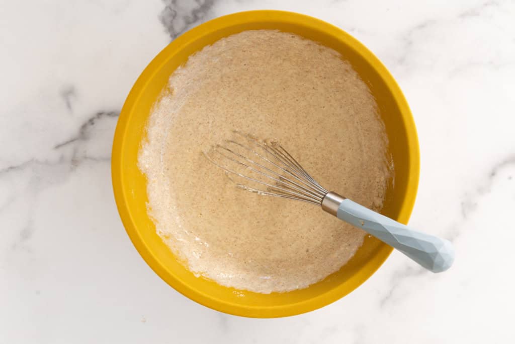 Batter for vegetable pancakes in yellow bowl.