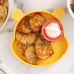 Vegetable pancakes on yellow plate with dip.