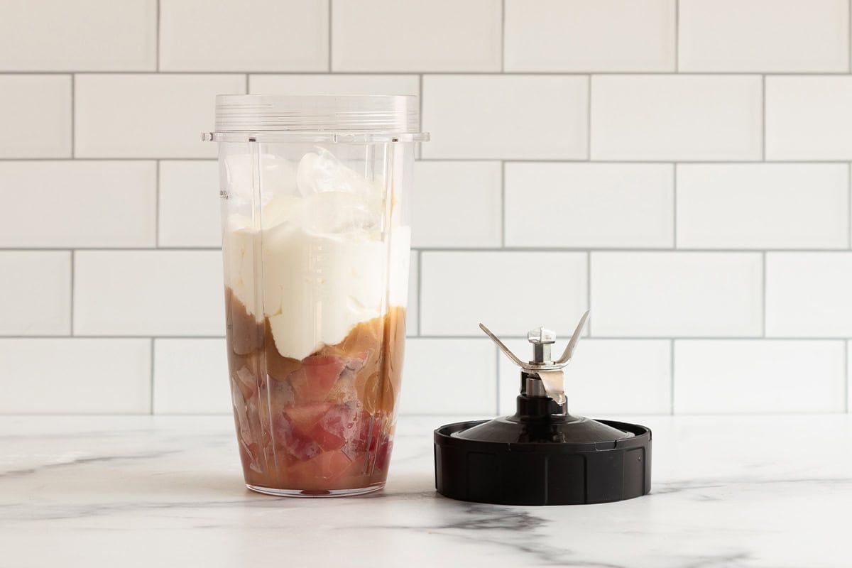 Apple smoothie in hand held blender before blending.