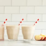 Apple smoothie in three glasses with straws.