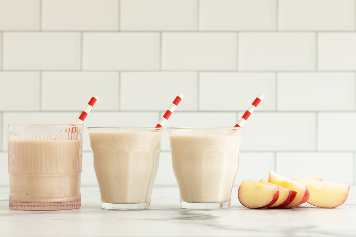 Apple smoothie in three glasses with straws. 