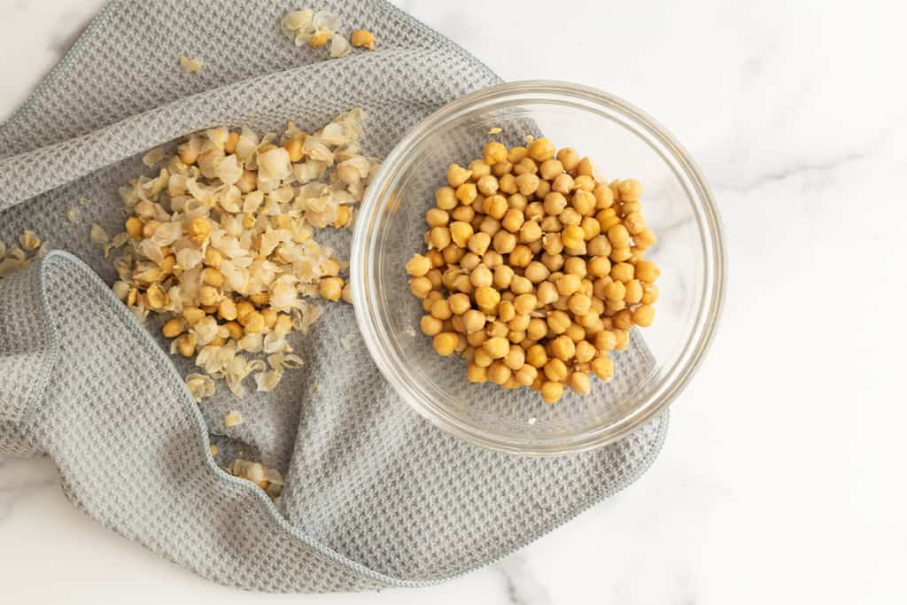 Chickpeas with shell removed in glass bowl.