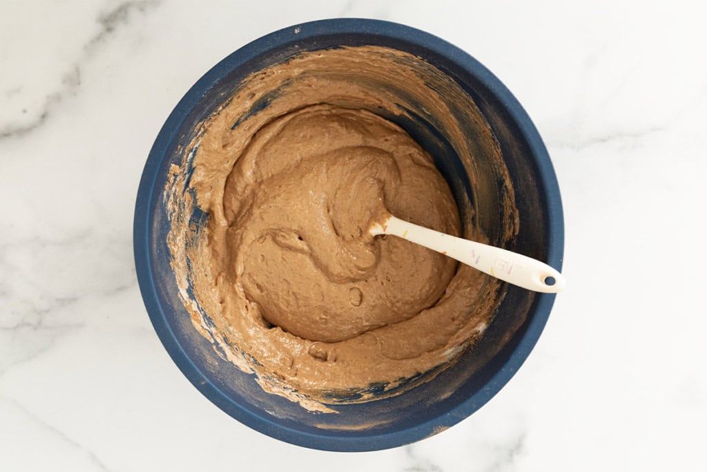 Batter for chocolate baked donuts in blue bowl.