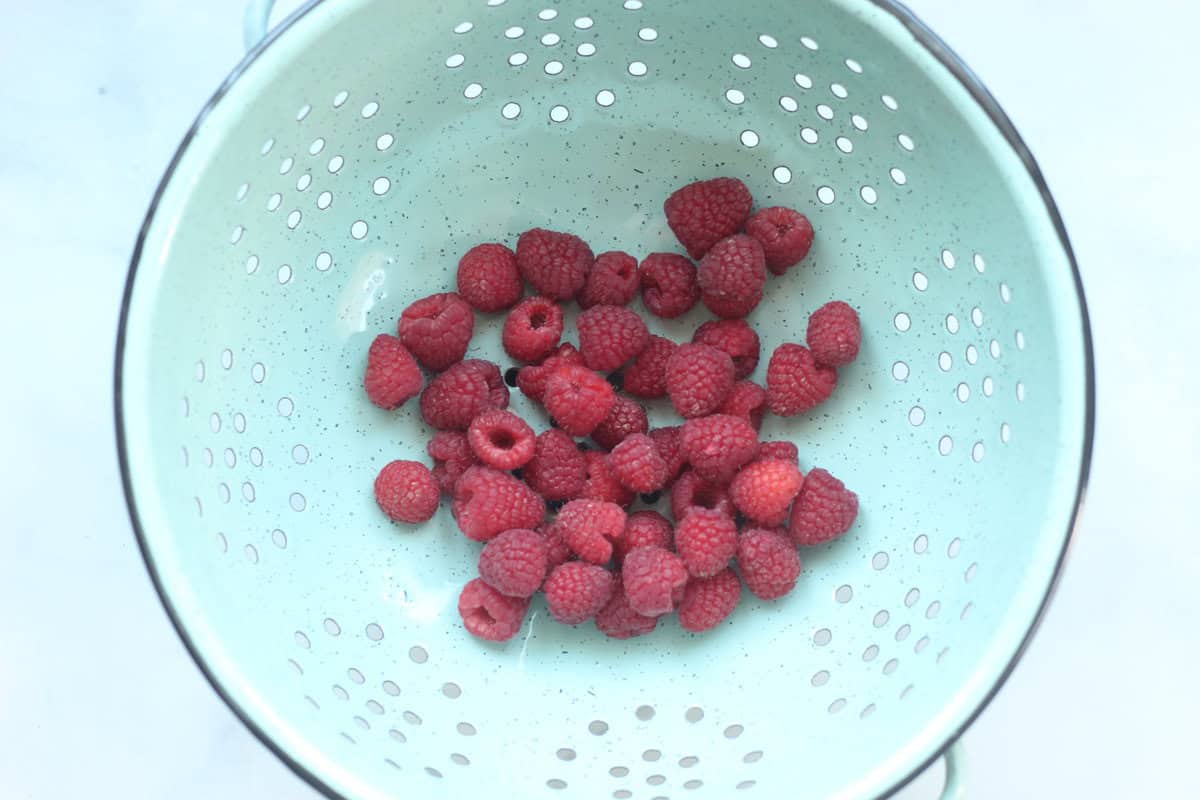 Raspberries in strainer for raspberry puree.