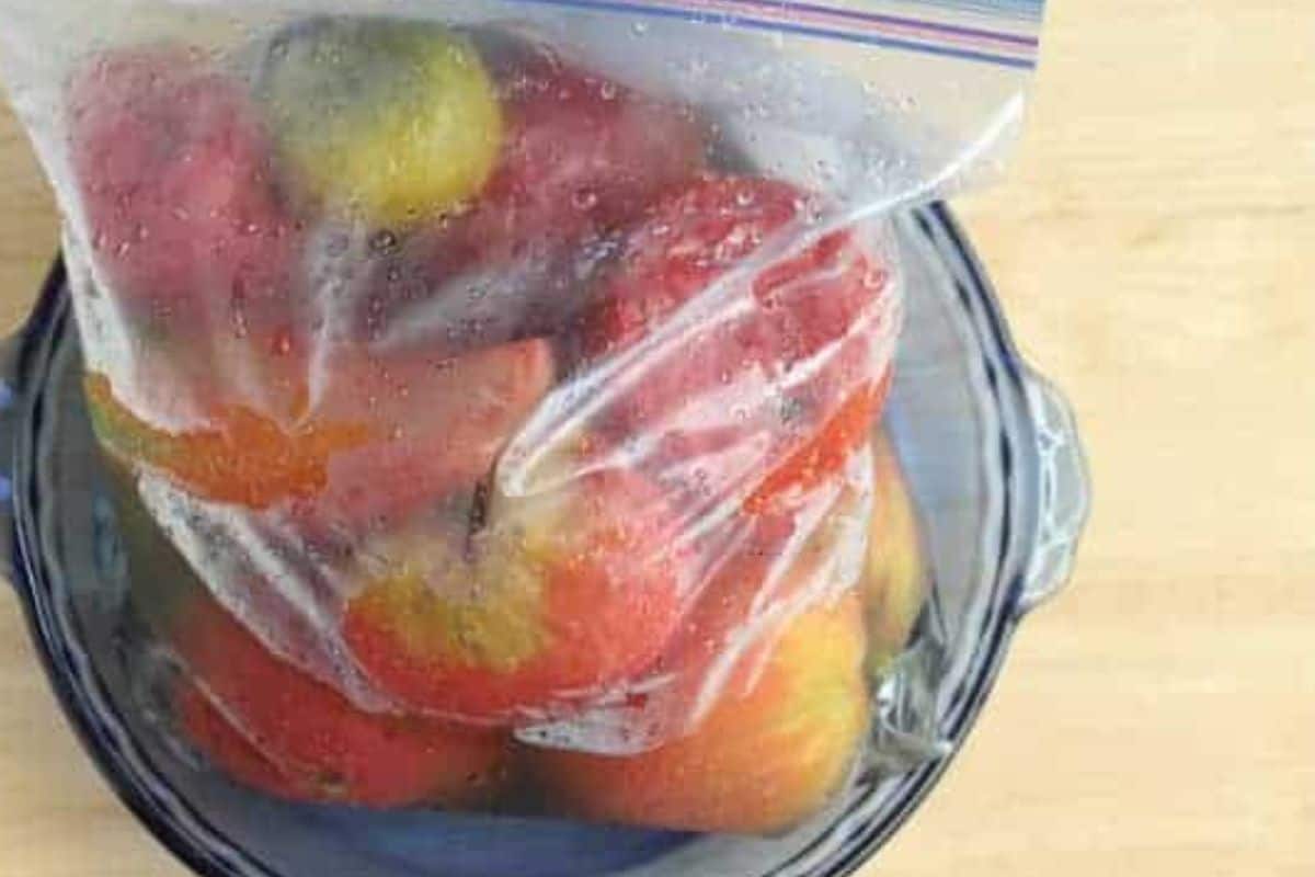 Tomatoes frozen in zip top freezer bag.