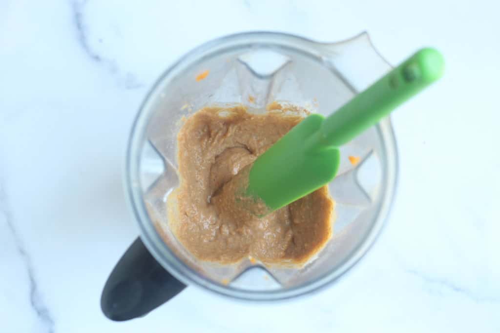 Sweet potato waffle batter in blender with spatula.