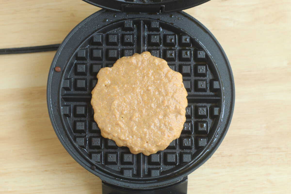 Sweet potato waffle batter in waffle iron before cooking.