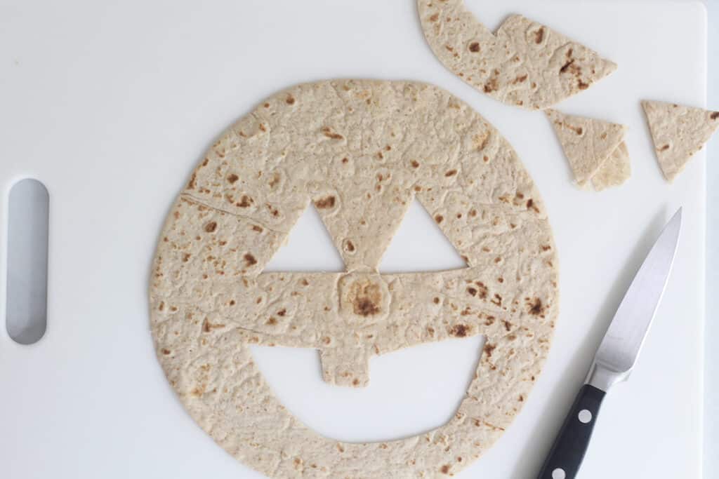 cutting out tortilla on cutting board.