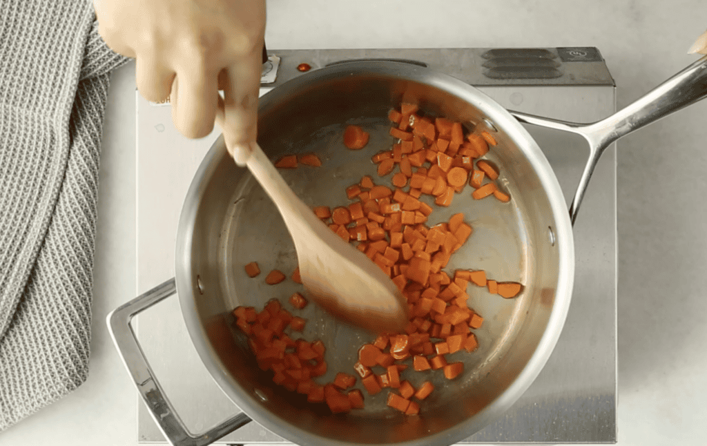 Carrots in pot for alphabet soup.