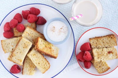 eggnog french toast on two plates with cups.