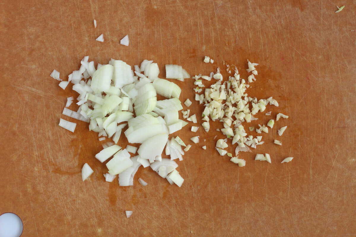 Onion and garlic on cutting board for minestrone soup. 