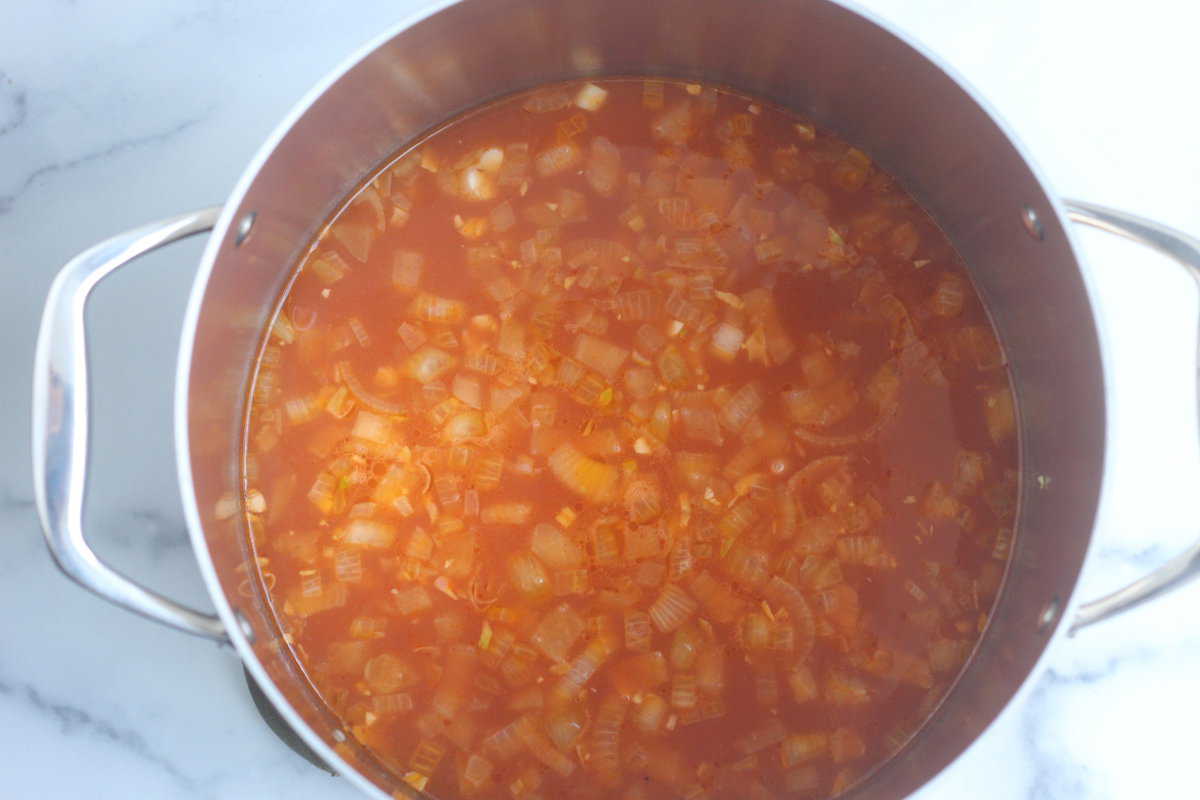 Onion and tomato sauce in pot for minestrone soup.