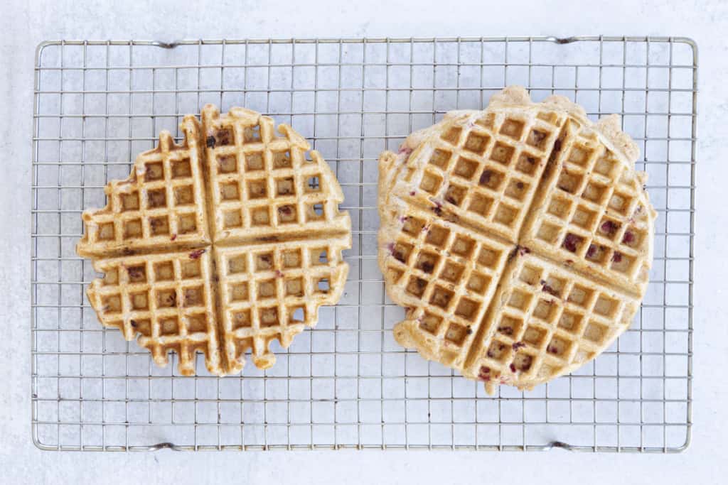 Waffles with raspberries on cooling rack.