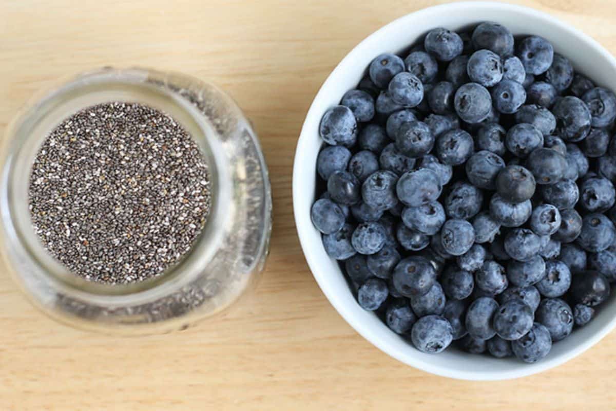 Blueberries and chia seeds in bowl and jar. 
