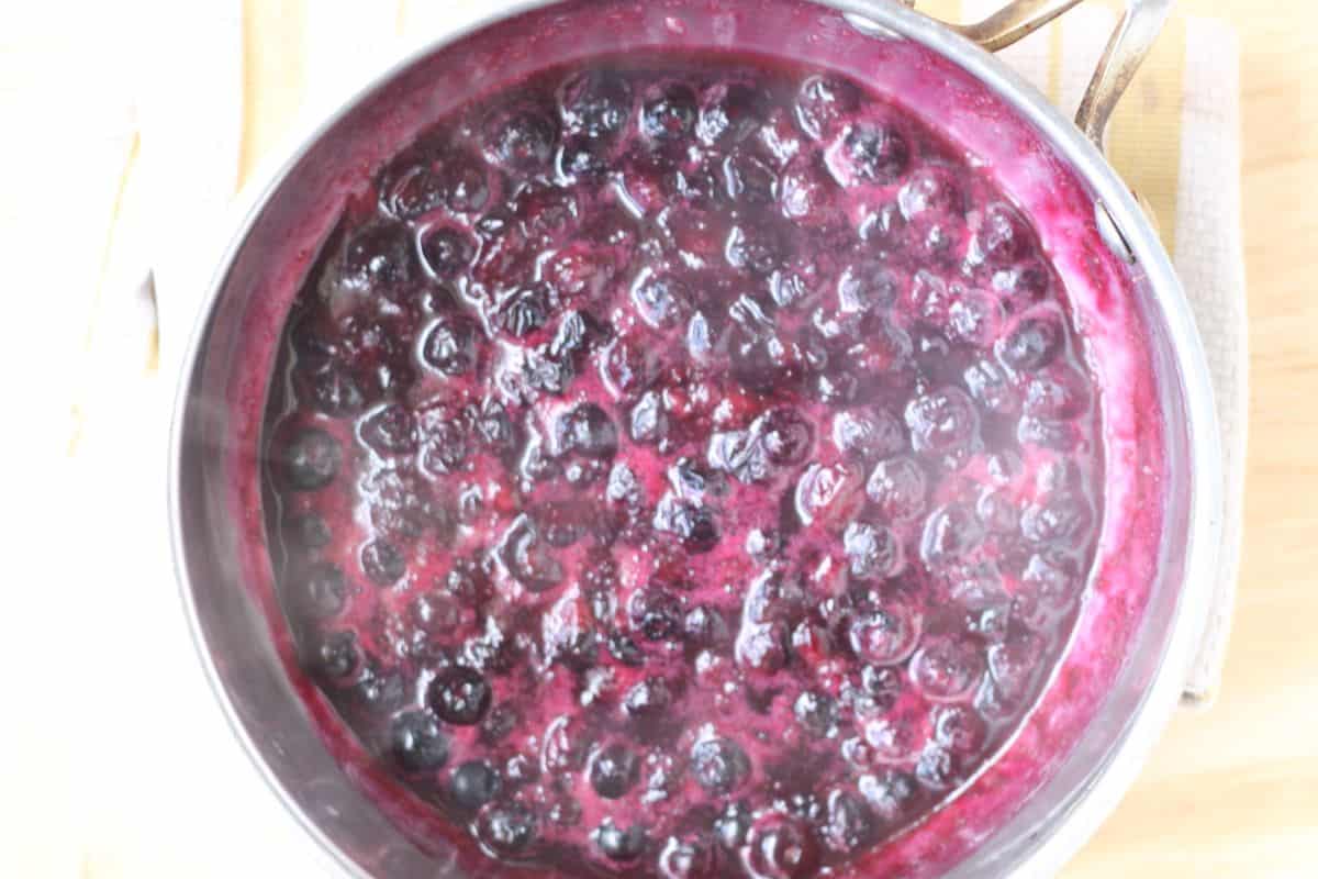 Blueberries cooked in pan for blueberry jam.