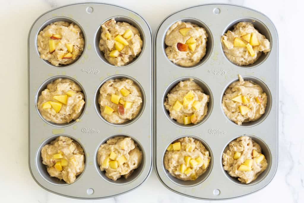 Peach muffins in muffin pan before baking.