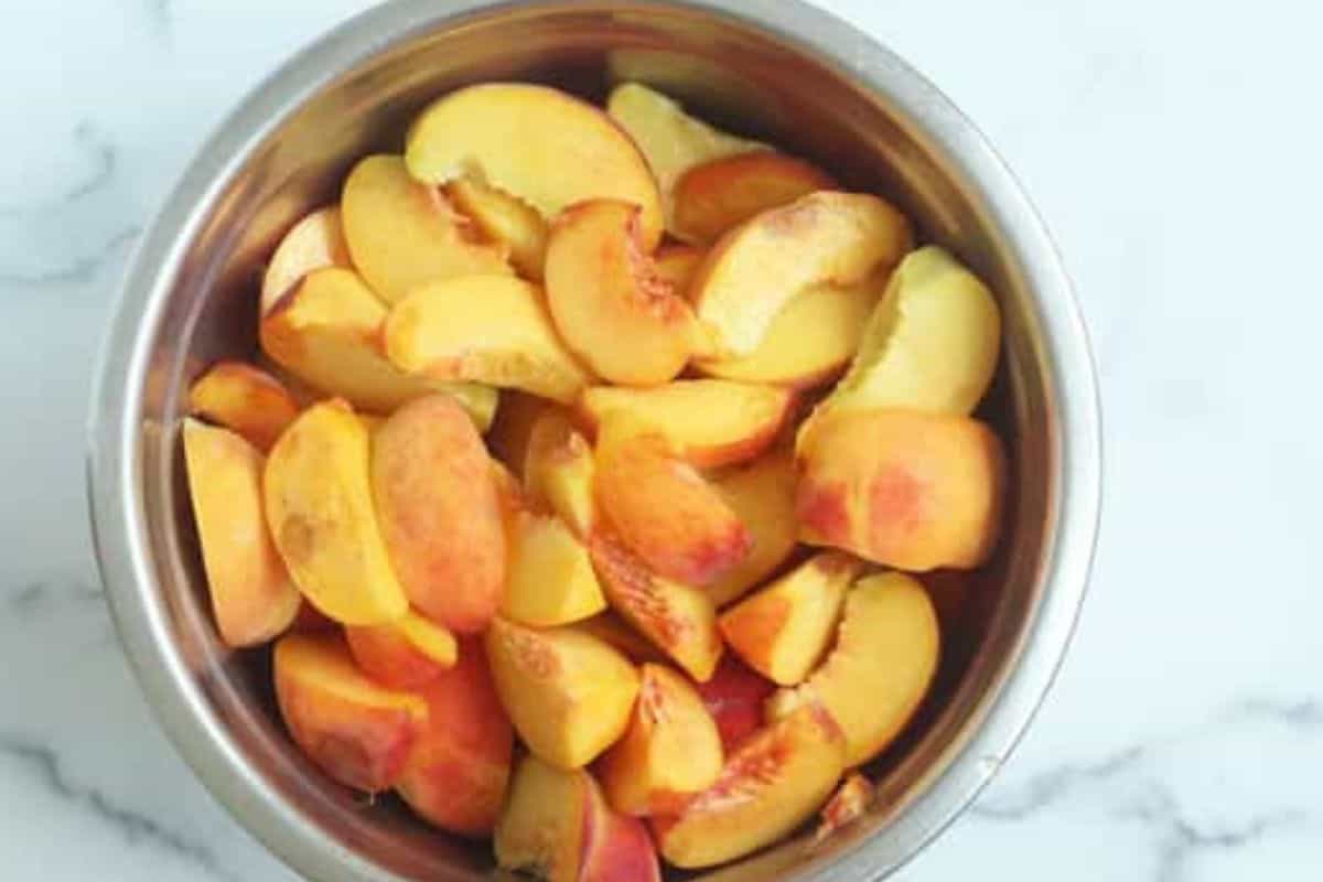 Sliced peaches in large pot for canned peaches.