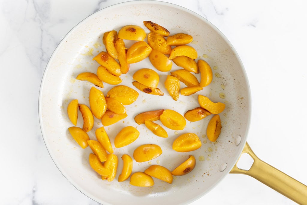 sliced apricots in white pan.