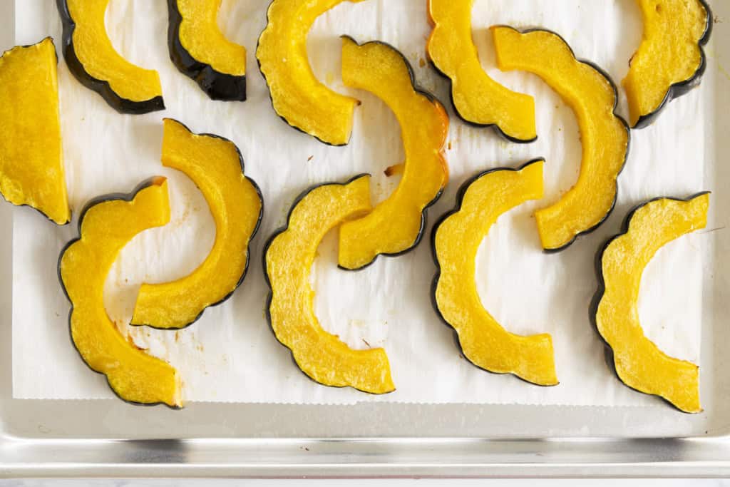 Acorn squash slices after cooking on baking sheet.