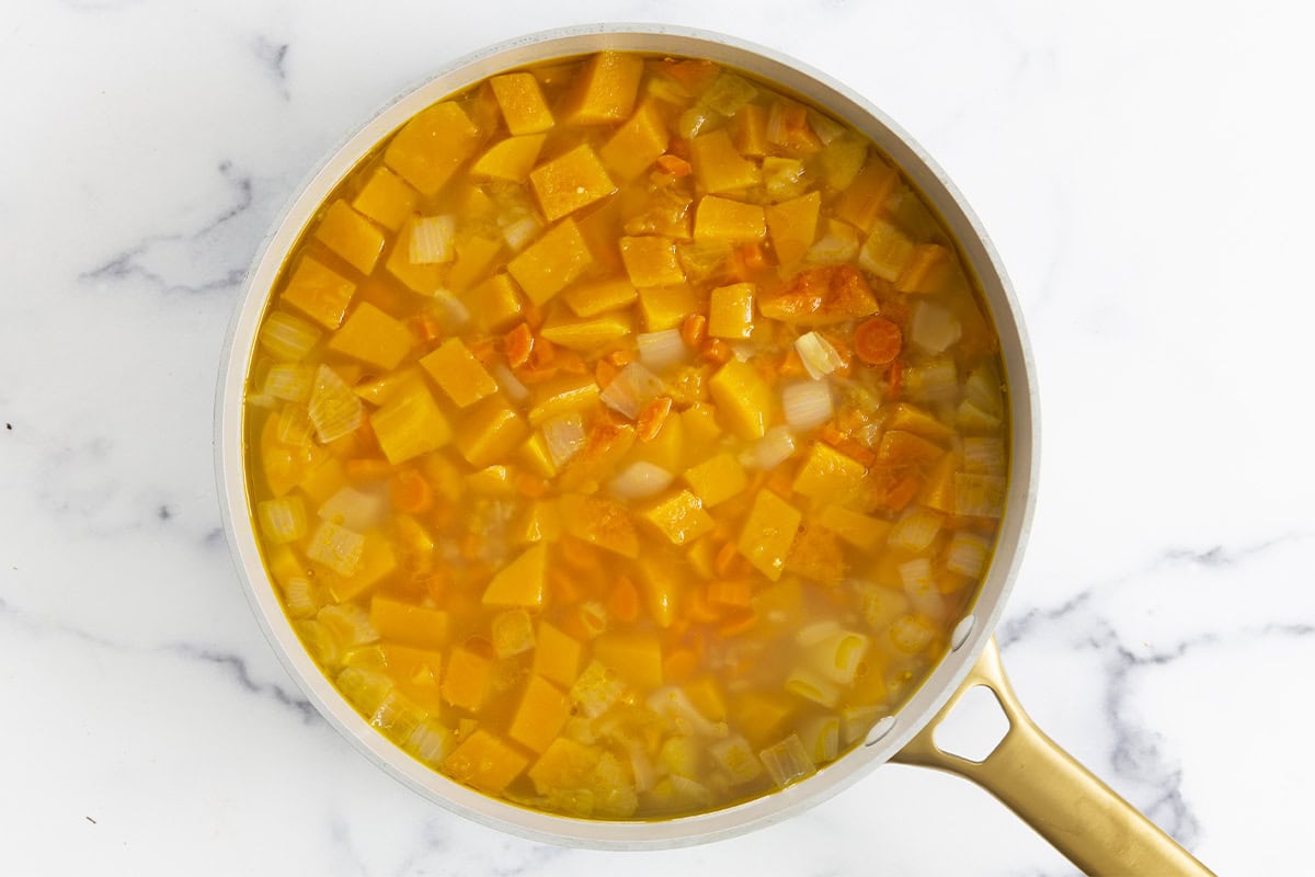 Butternut squash soup in pot after adding broth.