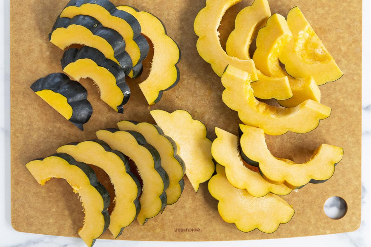 Slices of acorn squash on cutting board.