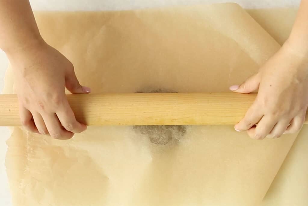 rolling out easy gingerbread dough between parchment paper.