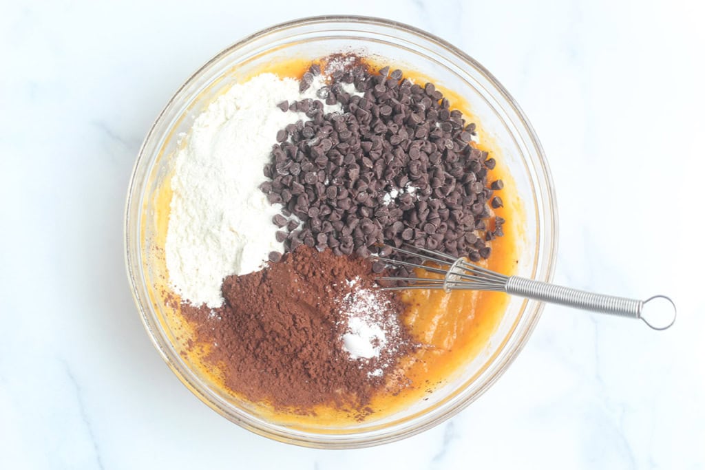 Ingredients for sweet potato brownies in glass bowl before mixing.