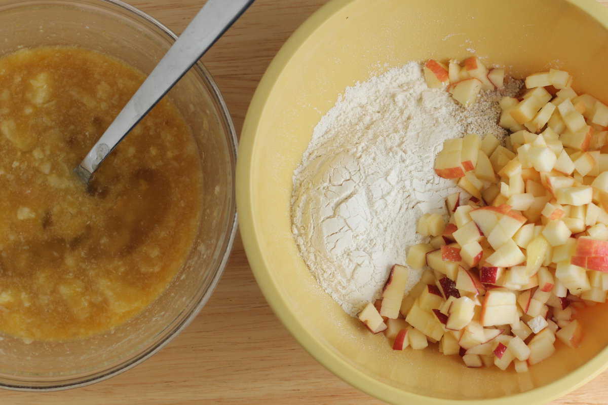 Two bowls with ingredients for apple cake in them. 