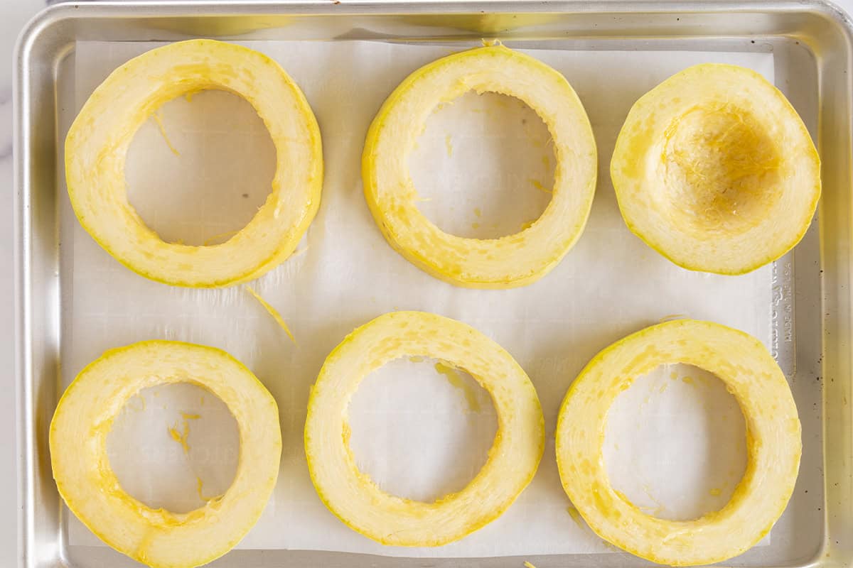 Rings of spaghetti squash on baking pan before cooking.