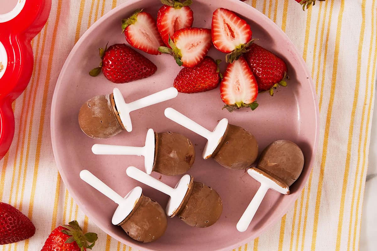 https://www.yummytoddlerfood.com/wp-content/uploads/2023/04/fudge-pops-with-strawberries-on-pink-plate.jpg