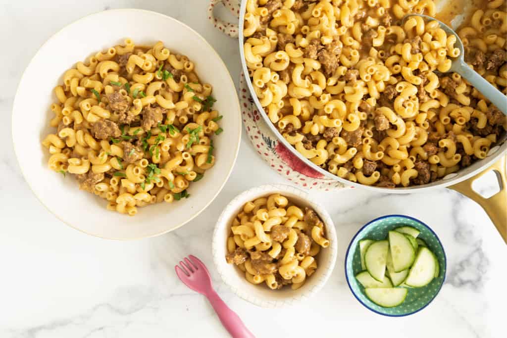 hamburger helper in various bowls and pan.