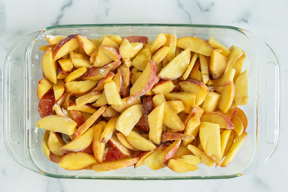 Peaches in baking pan for peach crisp.