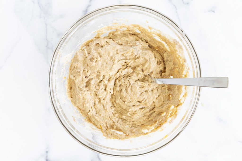 Batter for apple cinnamon muffins in glass bowl.