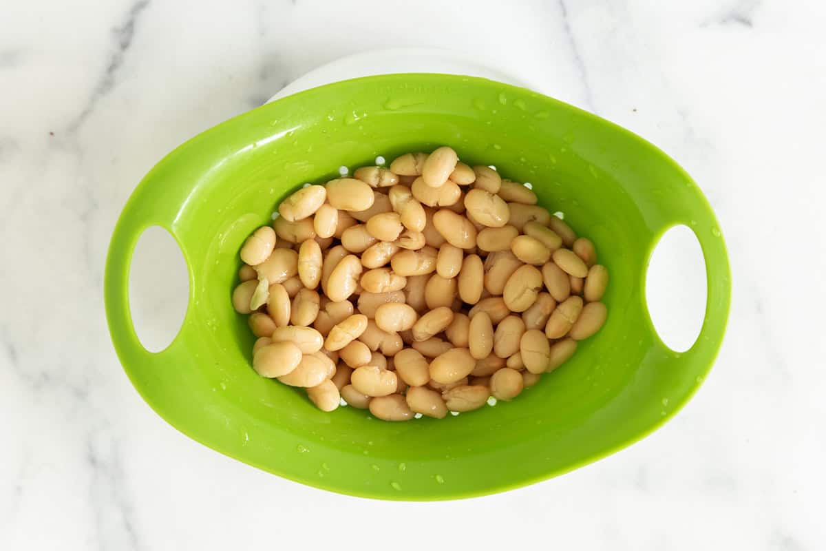 White beans in strainer for carrot soup.