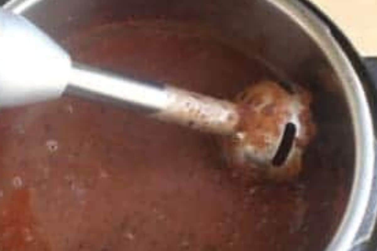 Black bean soup being pureed in slow cooker.