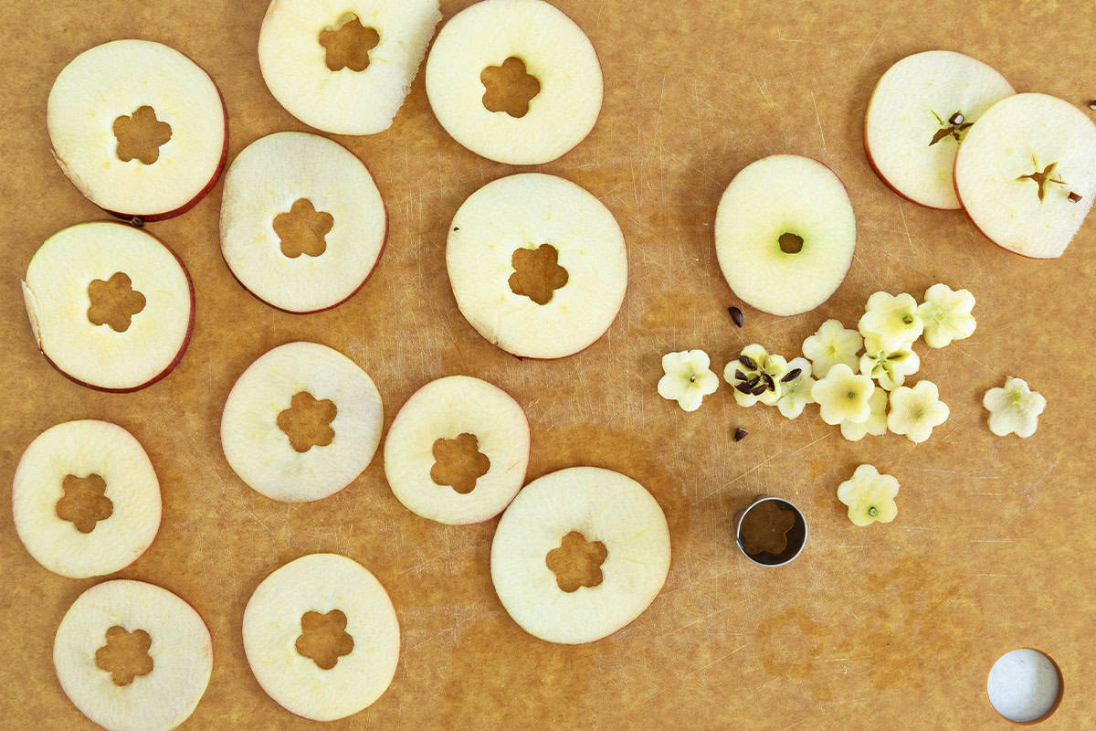 Apples being cut on cutting board for apple cinnamon pancakes.