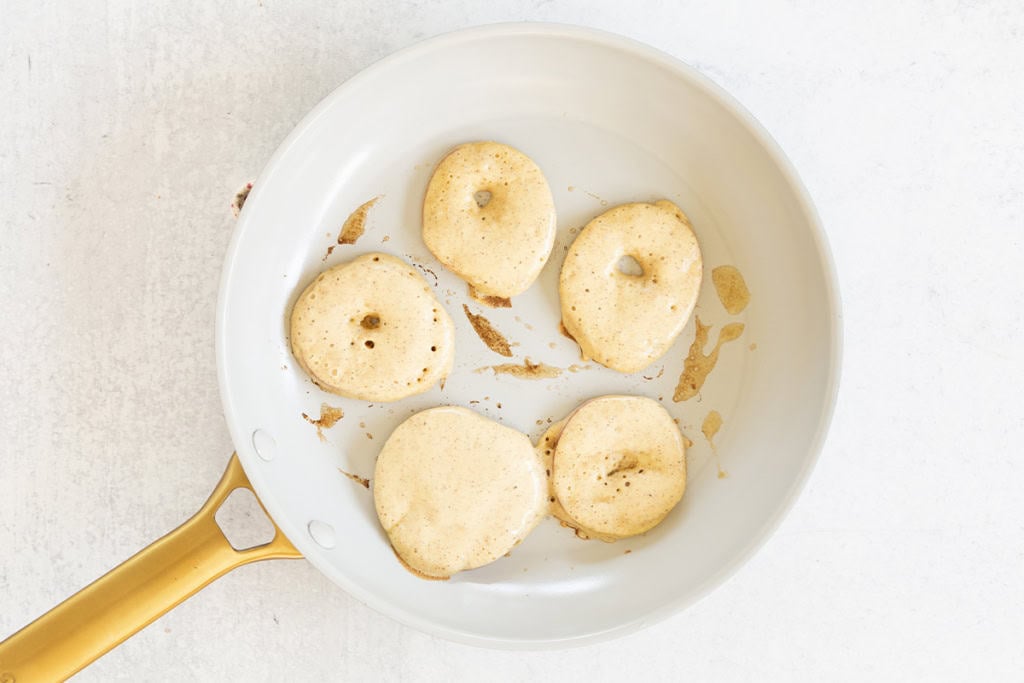 Apple cinnamon pancakes in pan before flipping.