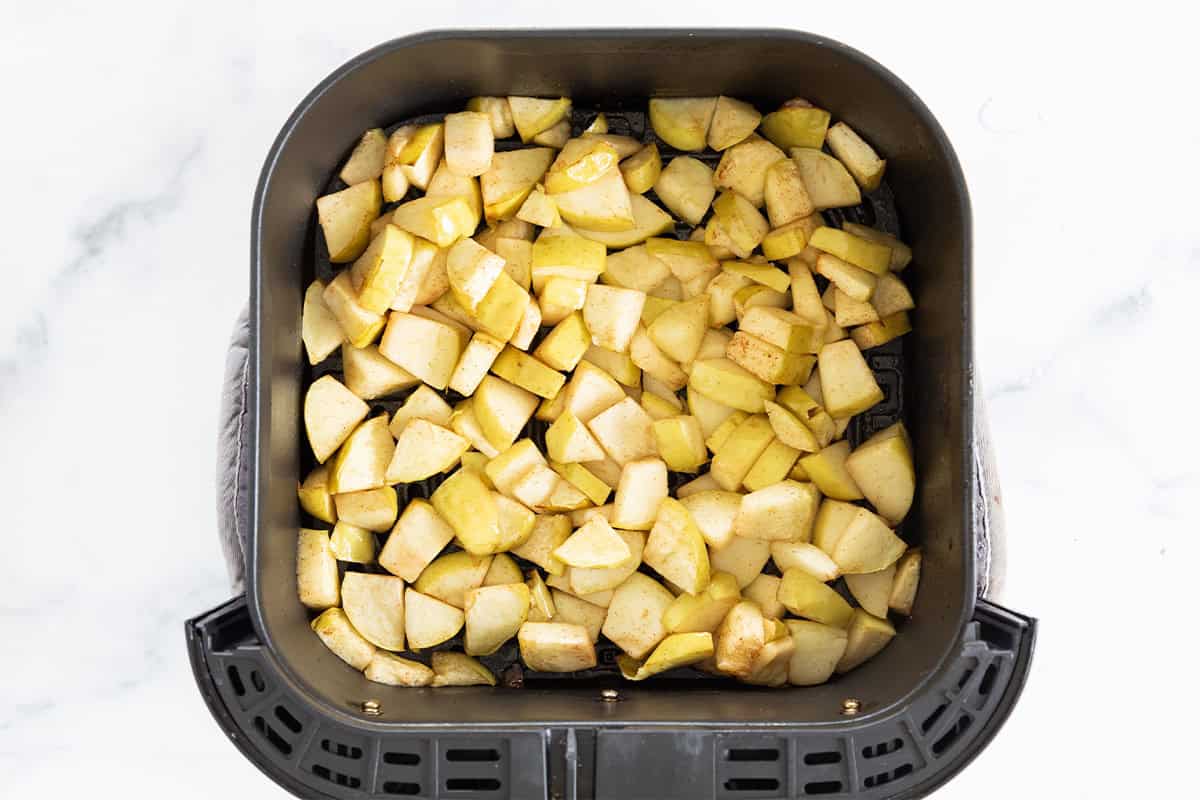 Air fryer apples in air fryer basket before cooking.