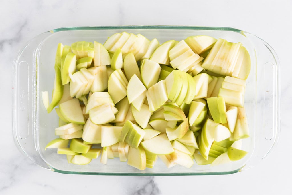 Cut apples in pan for apple crisp.