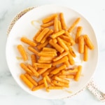 Roasted baby carrots on white plate.