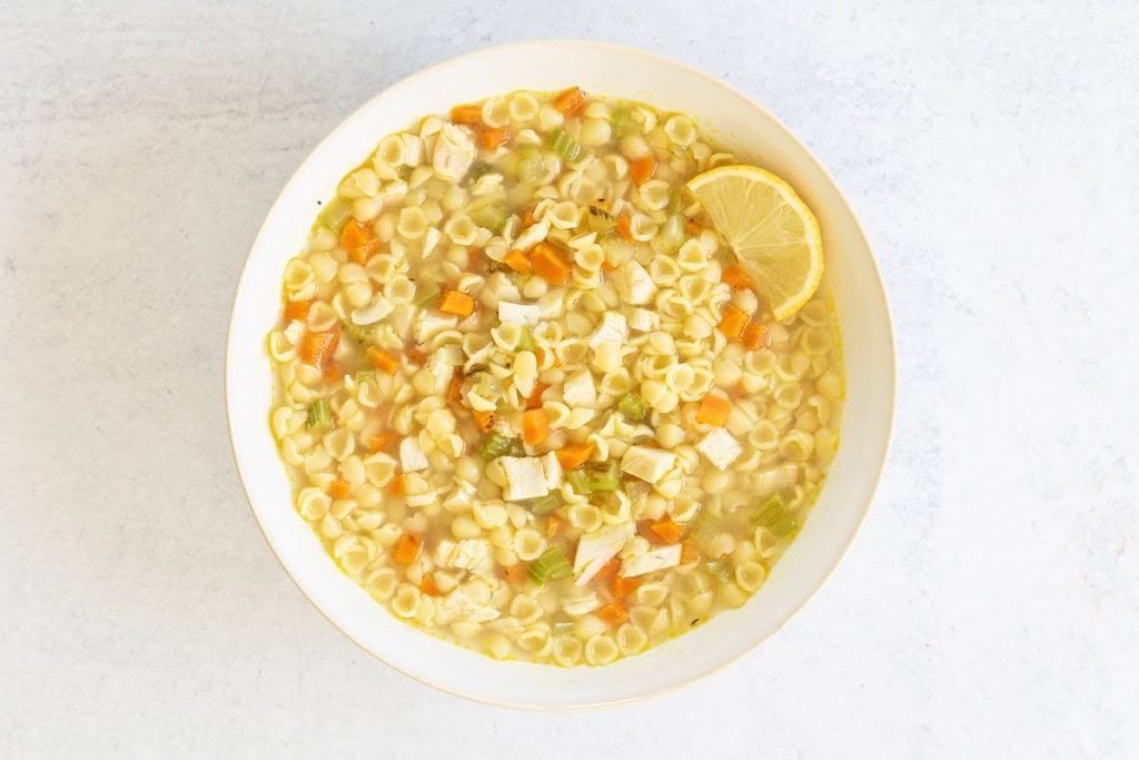 Turkey noodle soup in a white bowl.