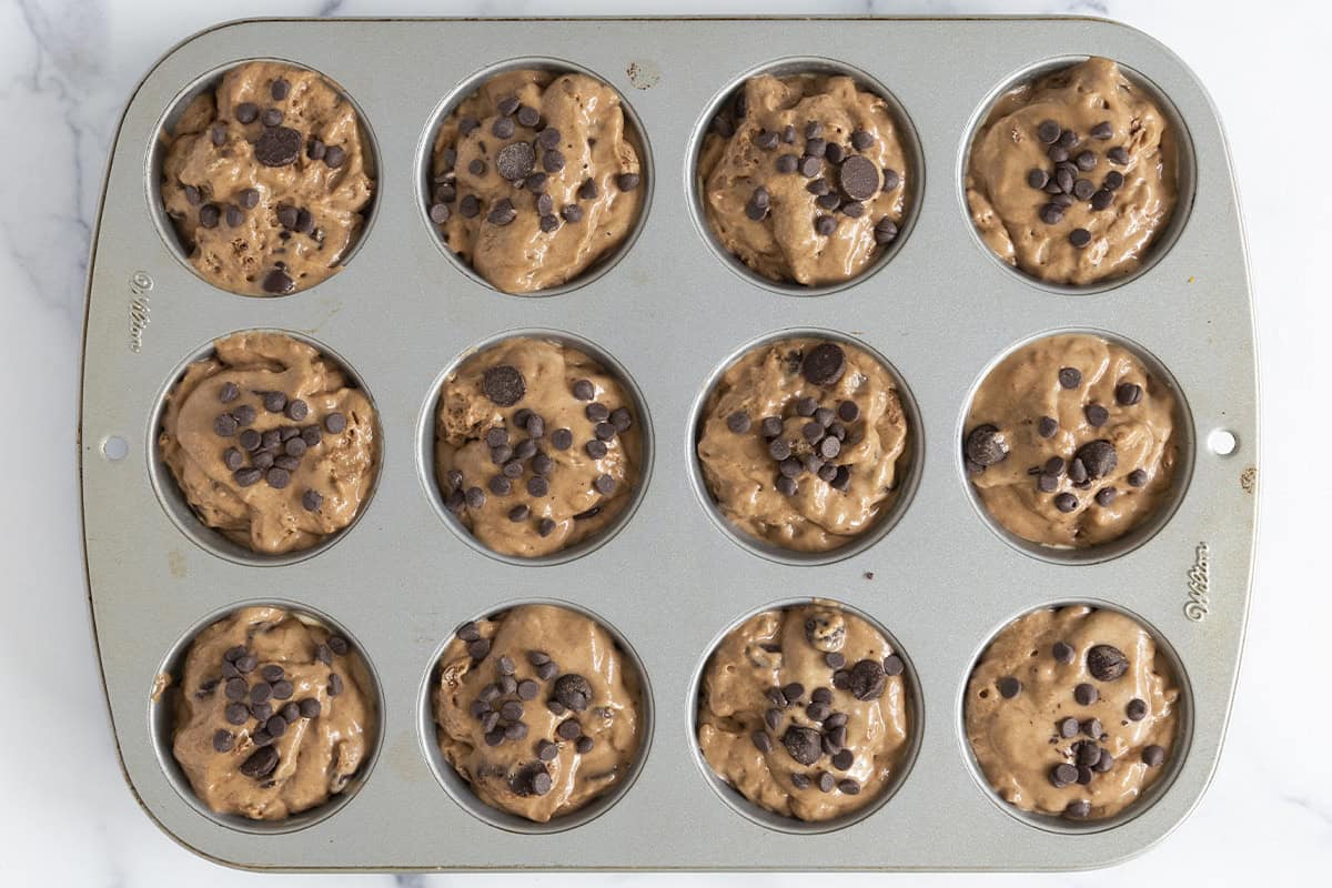 Chocolate muffins in muffin pan before baking. 