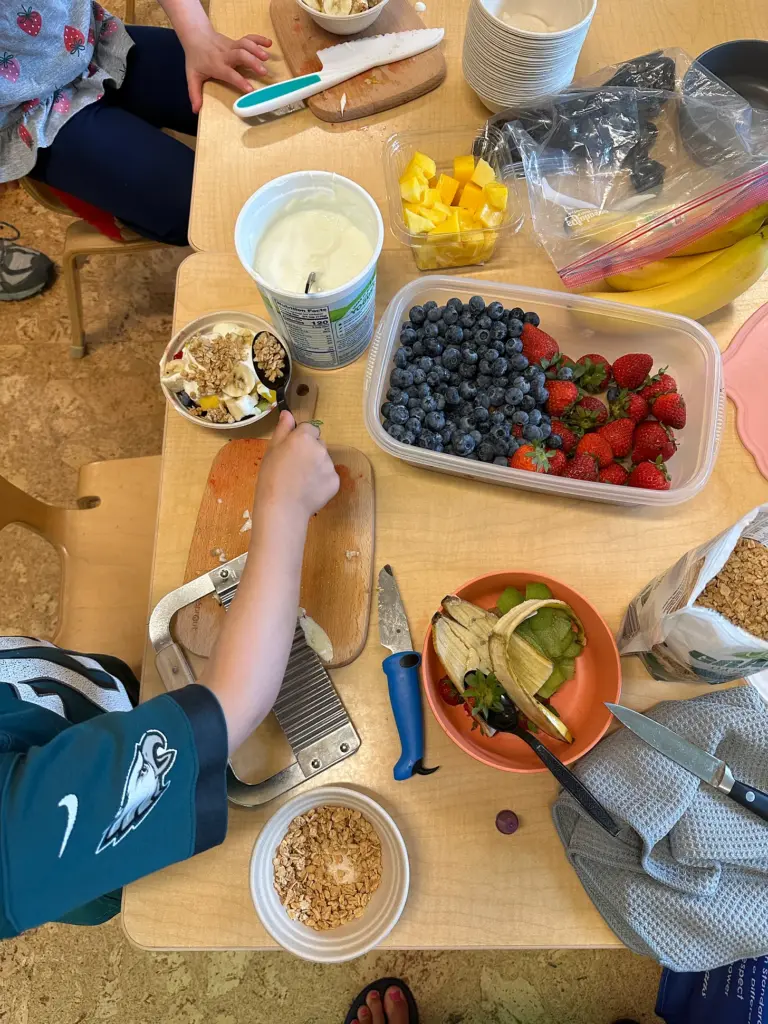 Table filled with snack foods and children.