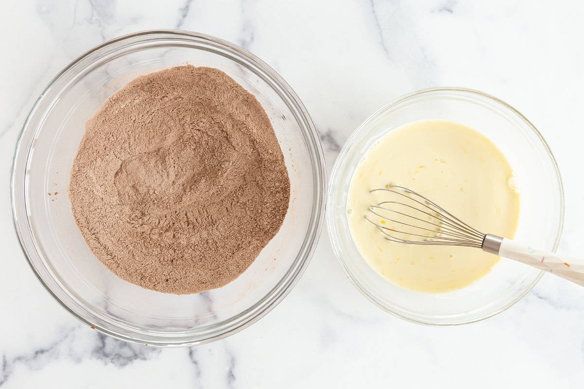 Wet and dry ingredients in two bowls for chocolate pancakes. 